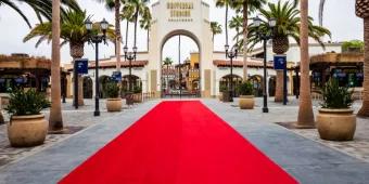A red carpet leading up to an archway which reads Universal Studios Hollywood