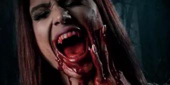 A woman screaming and holding her face with blood on her hands and chin