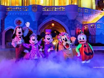 Mickey, Minnie, Goofy, Pluto and Donald Duck posing in Halloween costumes