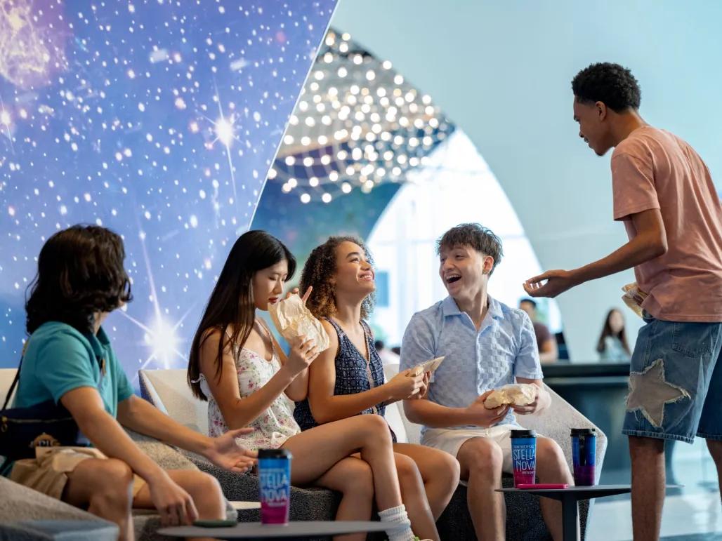 Guests eating pizza in the lobby at Universal Stella Nova Resort