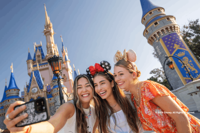 Three guests taking a selfie outside Cinderella Castle