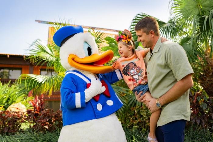 Dad holding his child in front of Donald 