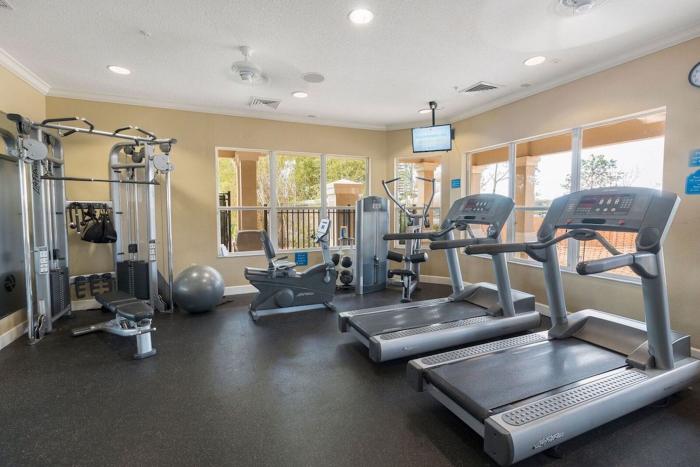 An indoor resort fitness center featuring Life Fitness treadmills, stationary bikes, and weight training equipment.