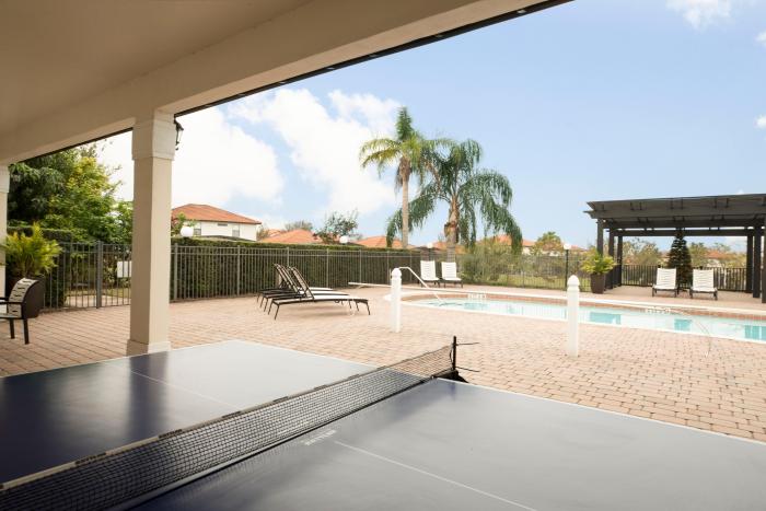 Covered patio with ping pong table overlooking the pool and hot tub at High Grove Resort