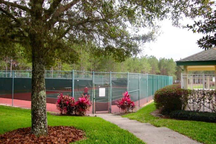 Fenced tennis courts surrounded by trees at Highlands Reserve