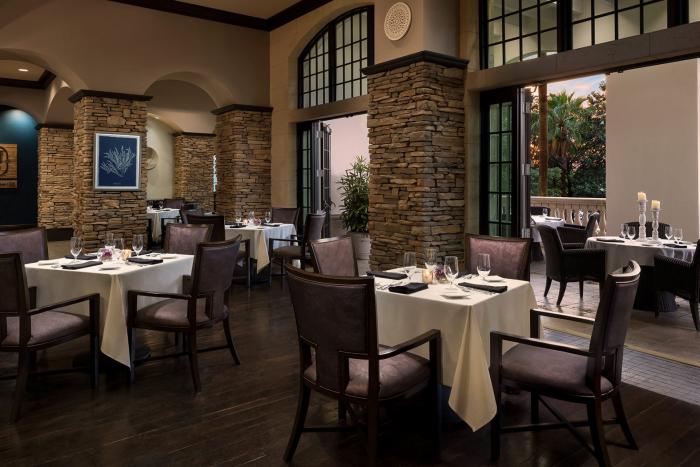 Elegant indoor-outdoor dining room with stone columns at the Chophouse restaurant, Reunion Resort