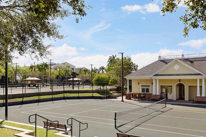 Outdoor tennis courts with benches near the clubhouse at Reunion Resort Orlando