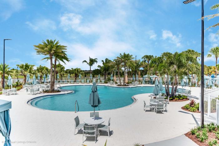 Main resort pool with lounge seating and palm trees at Solara Resort