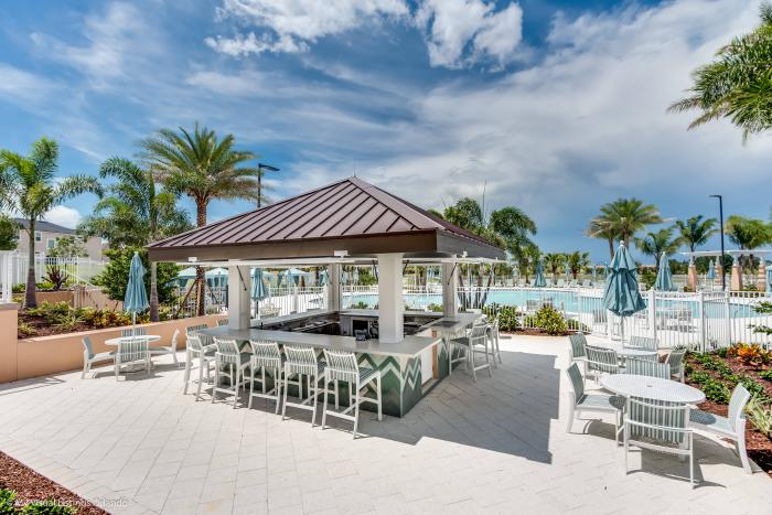 Outdoor bar seating area next to the resort pool at Solara Resort