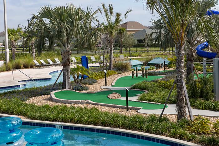Mini golf course alongside a lazy river with blue inner tubes