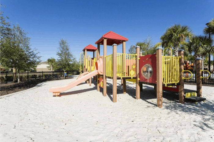 Outdoor children's playground at Solterra Resort with slides and climbing frames set in white sand.