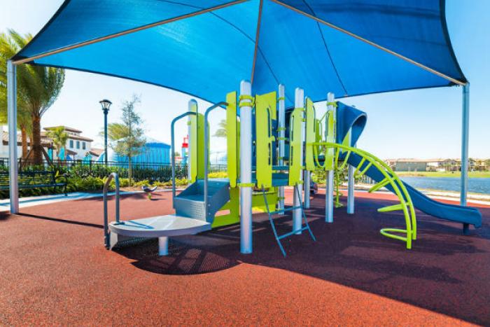 Shaded playground with climbing structures and slide at Windsor at Westside