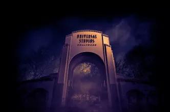 A large archway reading Universal Studios Hollywood surrounded by fog at night