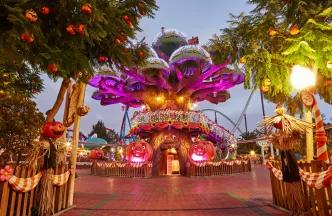 A large cartoon style tree decorated with sparkling lights and pumpkins