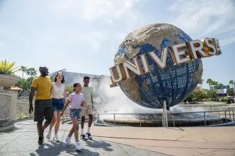 A family walking in front of the Universal globe at Universal Orlando Resort