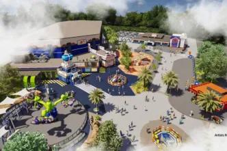 Misty theme park with spinning rides, lego statues and a large building with space theming on it.