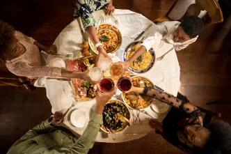 A bird's eye view of a family sat round a table cheersing their drinks