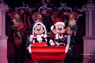 Mickey and Minnie in Santa outfits on a sleigh in front of reindeer