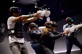 Sandbox VR in Orlando A group of adults shooting fake guns in a VR experience