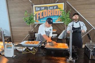 Buffet style food served by a chef in clean, modern restaurant with another chef stood behind.