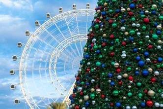 The orlando eye with a christmas tree in front of it.