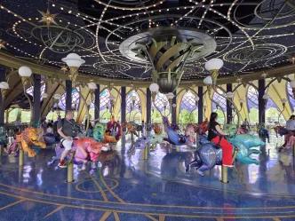 People sat on a carousel made of hand carved animals, including lions, bulls and other animals associated with zodiac signs.