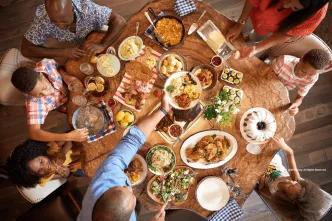 Overhead view of a family enjoying a shared, bountiful meal at a Table-Service restaurant at Walt Disney World.