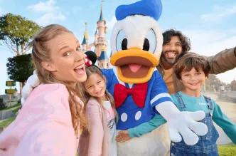 A happy family meeting Donald Duck at Disneyland Paris with the iconic castle in the background.
