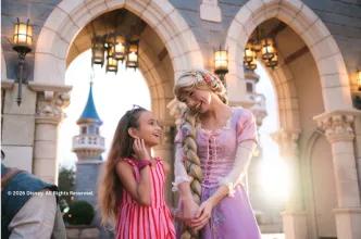 A young girl meeting Rapunzel in front of the castle at Disney World