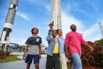 A family walking past large rockets at the Kennedy Space Center Rocket Garden