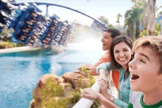 A family laughing and cheering as Manta roller coaster splashes down beside them at SeaWorld Orlando