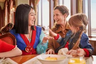 Mulan interacting with a mother and young girl during character dining at The Regal View Restaurant & Lounge