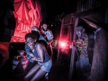 Guests scream as a scareactor lunges at them in one of Universal’s haunted houses at Halloween Horror Nights, Universal Orlando