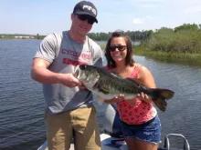 Trophy Bass Fishing Two people smiling as they hold a fish they have caught.