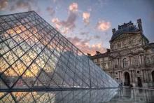 The Louvre Museum The glass pyramid of The Louvre museum in front of a sunset
