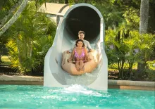A couple on a raft coming out of a water slide