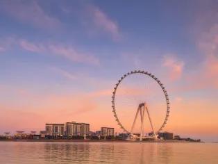 Dubai Parks and Resorts Pick a Park + Ain Dubai Combo Ticket Ain Dubai Ferris wheel against a sunset sky, Dubai skyline in the distance