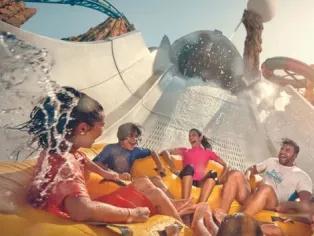 Yas Island, Abu Dhabi Four people laughing on a water slide at Yas Waterworld.