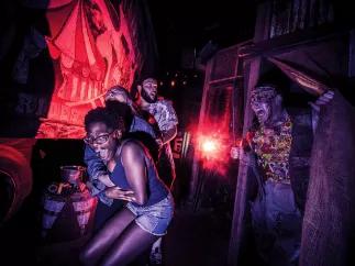 Guests scream as a scareactor lunges at them in one of Universal’s haunted houses, Halloween Horror Nights at Universal Orlando