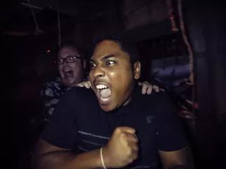 Halloween Horror Nights Two men in a haunted house screaming at something to their right