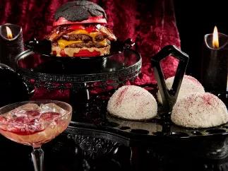 Food and Drink at Halloween Horror Nights 2023 Snowball cakes, a double cheeseburger with a red bun and a cocktail against a black and red background