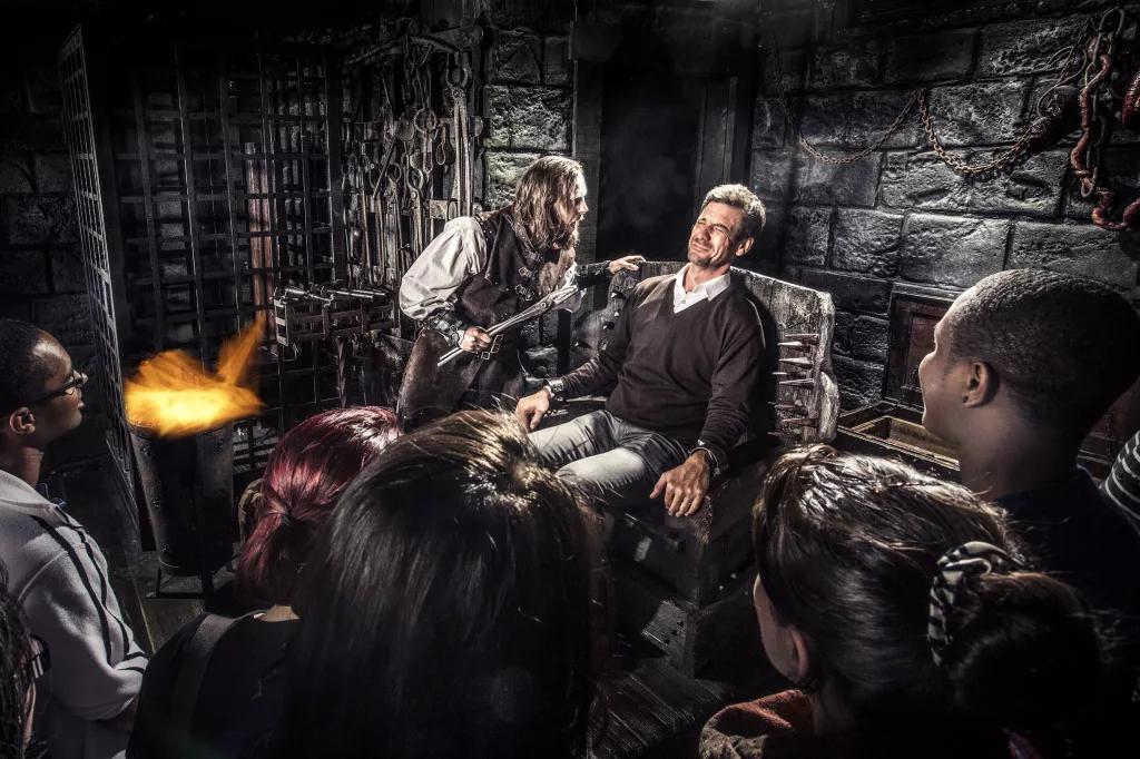 The Torture Chamber at London Dungeon People taking part in the torture chamber scene at the London Dungeon
