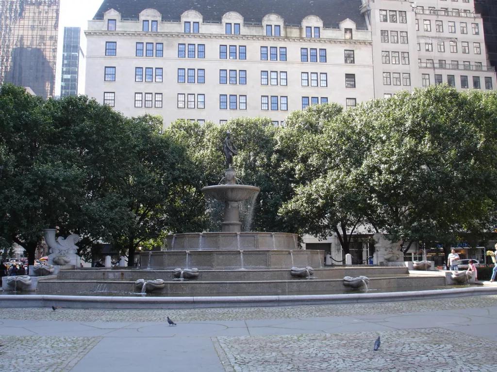 Pulitzer Fountain New York A large fountain in front trees and buildings in New York