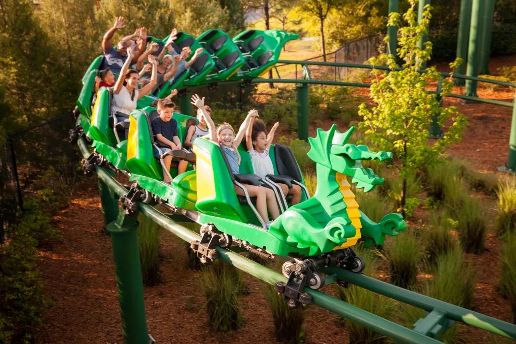 The Dragon at Legoland Guests riding the Dragon rollercoaster with their arms up in the air