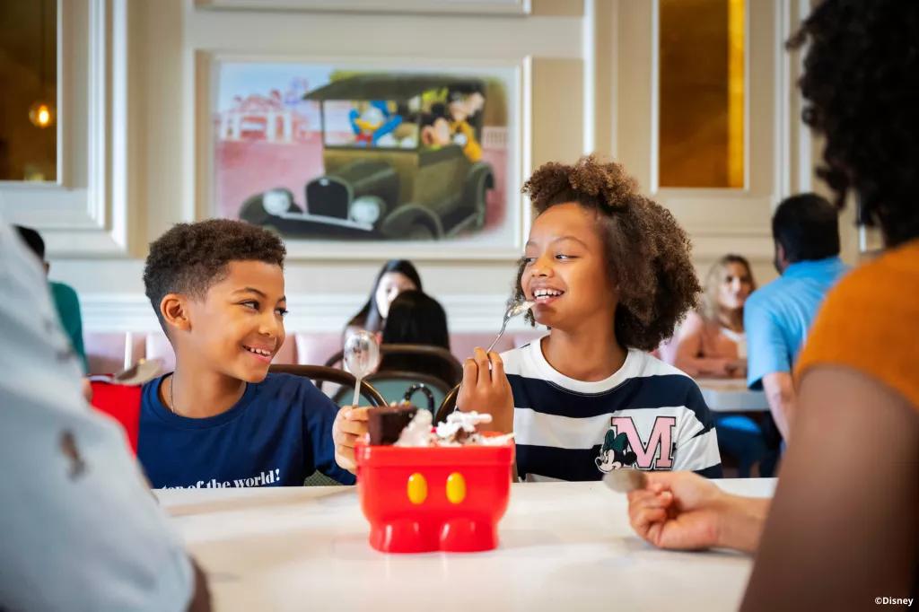 Ice Cream at Beaches and Cream Soda Shop Two young children eating an ice cream sundae from a bowl shaped like Mickey Mouse's shorts