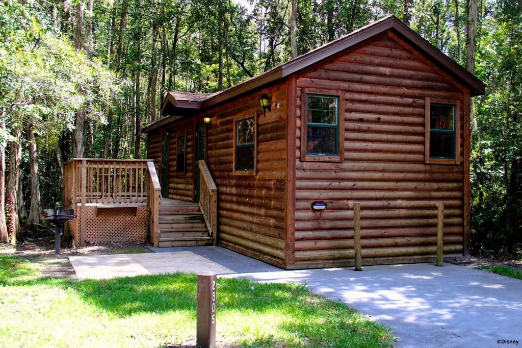 The Cabins at Fort Wilderness A log cabin at Fort Wilderness surrounded by trees in the background