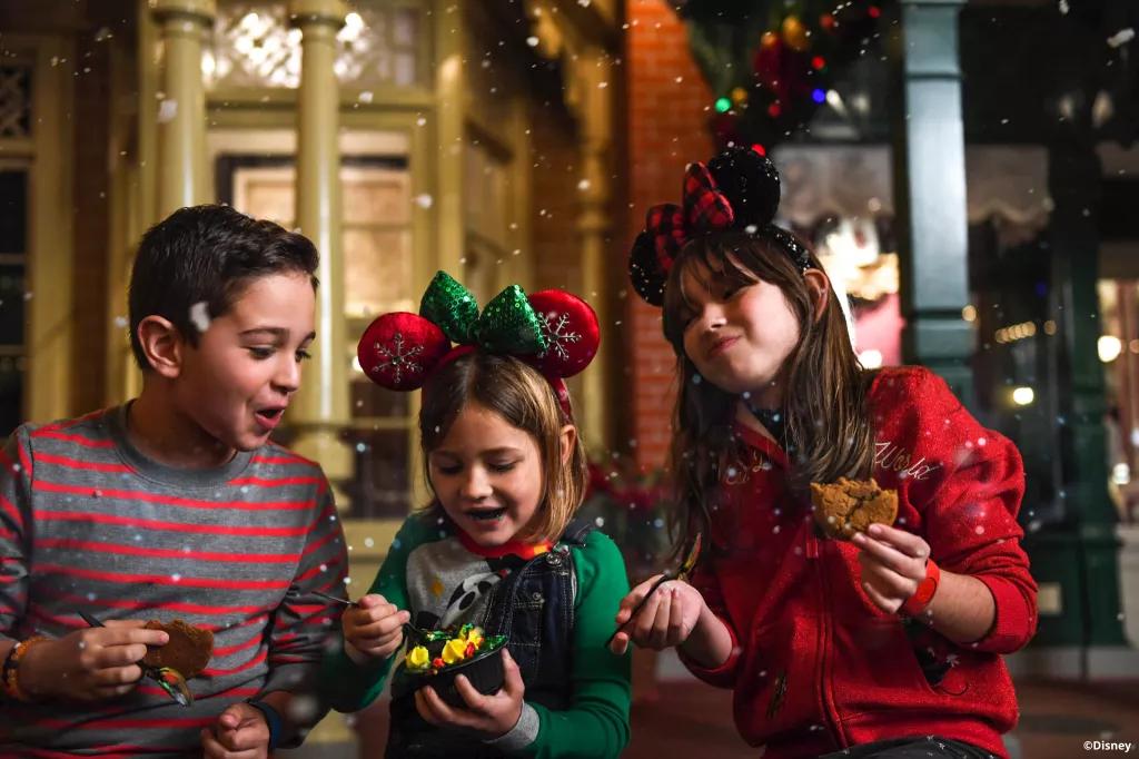Christmas cookies at Mickey's Very Merry Christmas Party Two girls and a boy eating cookies and wearing Christmas jumpers