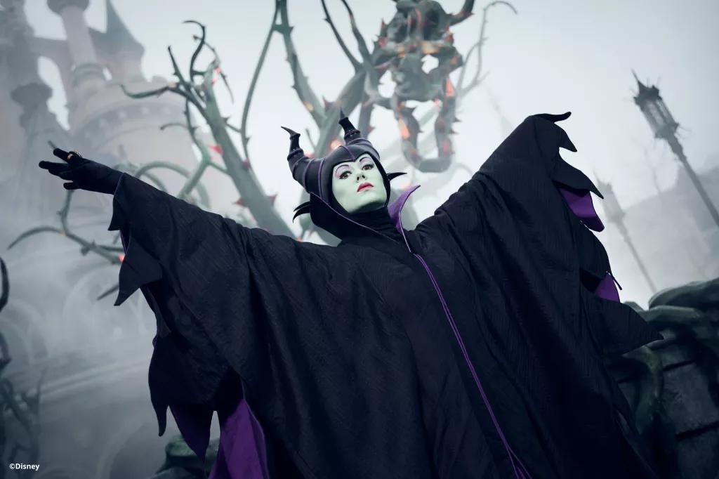 Maleficent at Disney's Halloween Festival Maleficent standing with her arms outstretched in front of vines and fog