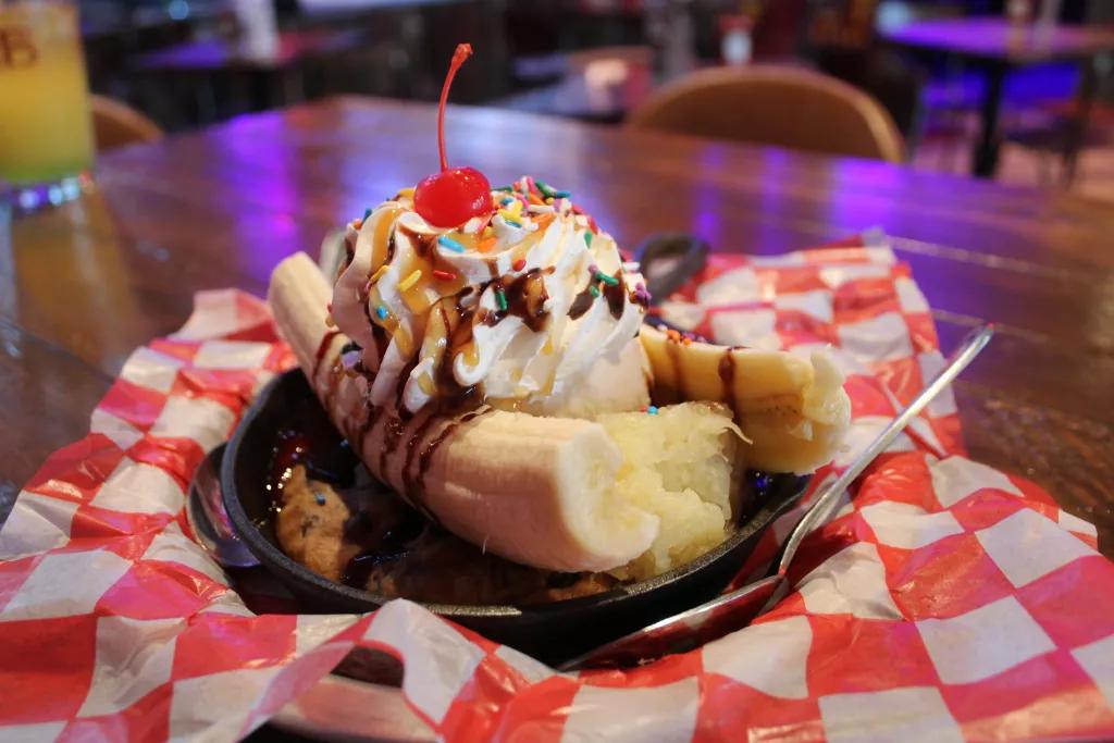 Ole Red Banana Split A banana split in a cookie skillet on top of a gingham cloth