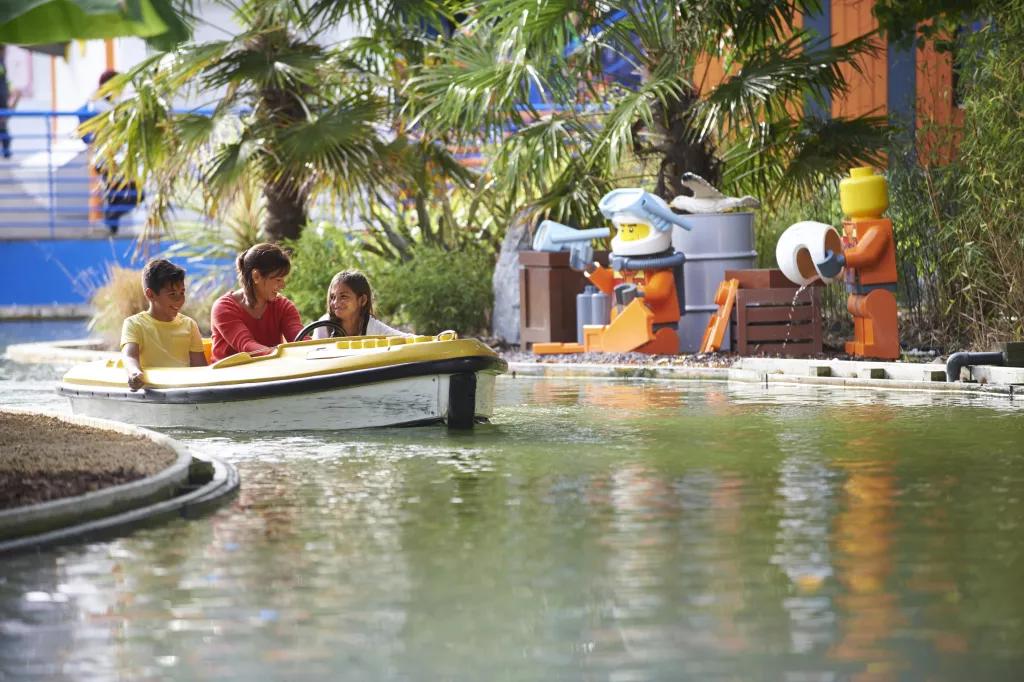 Coastguard HQ A woman and two children riding a LEGO boat along a winding waterway